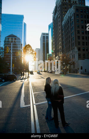 Zwei Frauen stehen In der Straße während des Sonnenuntergangs, Innenstadt; Vancouver, British Columbia, Kanada Stockfoto