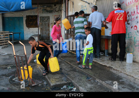 Rafah, Palästina. 29. Juli 2015. Palästinenser füllen Sie ihre Kunststoff-Flaschen und Kanister mit Trinkwasser aus einer öffentlichen Leitung im südlichen Gazastreifen Flüchtlingslager Rafah. Menschenrechte warnte verschlimmerten humanitären Lage Ausfall nach der Gaza alleinige Kraftwerk. © Ibrahim Khatib/Pacific Press/Alamy Live-Nachrichten Stockfoto