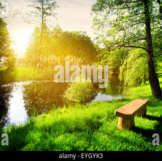 Holzbank Fluß im Sommerpark Stockfoto
