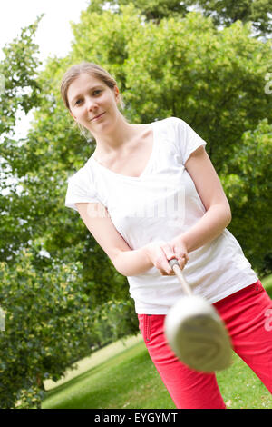 junge Frau mit einem Golfclub Vorbereitung zum Abschlag. Stockfoto