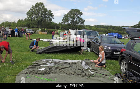 Zufällige Leute auf dem Campingplatz, die Zelte auf einem Feld aufstellen müssen Stockfoto