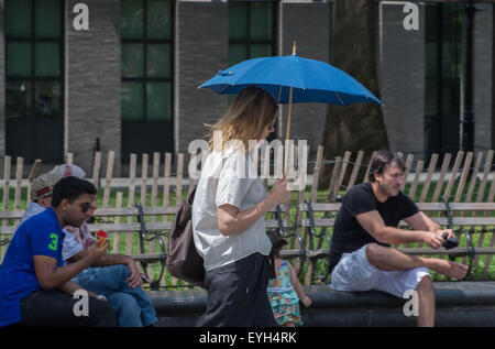 New York, NY, USA. 28. Juli 2015. Eine Frau geht mit einem Regenschirm im Washington Square Park, wie Hitze und Feuchtigkeit die Stadt Dienstag, 28. Juli 2015 greifen. Bildnachweis: Bryan Smith/ZUMA Draht/Alamy Live-Nachrichten Stockfoto