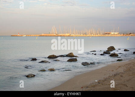 Erste Sonnenstrahlen schlagen die Masten in der Marina im Morgengrauen an der Playa de Palma in der Nähe von Can Pastilla, Mallorca Stockfoto