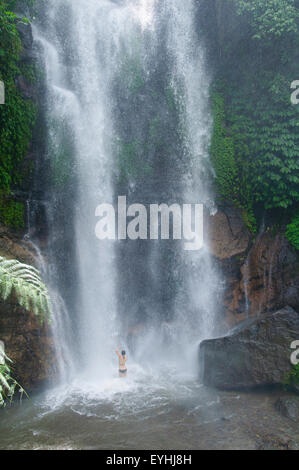 Mädchen badet in Munduk Wasserfall, Bali, Indonesien, Pazifik, Nein Herr Stockfoto