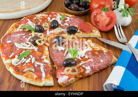 Selbstgemachte Pizza mit Gemüse auf einem Holztisch in Scheiben geschnitten Stockfoto