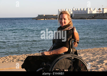 Frau mit einem Rollstuhl an einem Strand Stockfoto