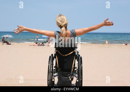 Frau mit einem Rollstuhl an einem Strand Stockfoto