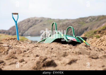 Aushubarbeiten in Whitesands Bay, Pembrokeshire Coast National Park, Wales, Großbritannien im Mai - umgedrehte Schubkarre und Spatenschaufel auf der Erde Stockfoto