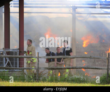 Plumpton, East Sussex, Großbritannien. Juli 2015. Die Feuerwehr enthält Feuer in der Heu- und Strohlagerscheune des Plumpton Agricultural College Stockfoto