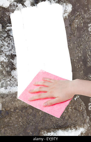 Wetter-Konzept - Hand löscht Schneeschmelze durch rosa Lappen aus Bild und weißem leeren textfreiraum erscheinen Stockfoto