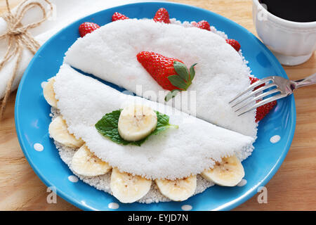 Casabe (Bammy, Beiju, Bob, Biju) - Fladenbrot aus Maniok (Tapioka) mit Erdbeeren und Bananen auf blaue Platte Stockfoto