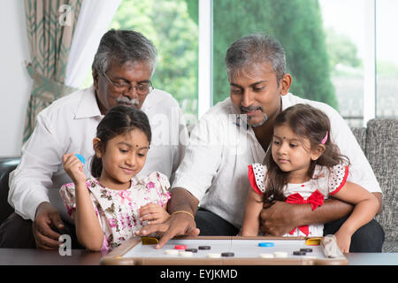 Glücklich Multi Generationen asiatischen indischen Familie Carrom Spiel zu Hause zu spielen. Großeltern, Eltern und Kinder indoor Lebensstil. Stockfoto