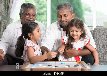 Glücklich Multi Generationen asiatischen indischen Familie Carambol Spiel zu Hause zu spielen. Großeltern, Eltern und Kinder indoor Lebensstil. Stockfoto