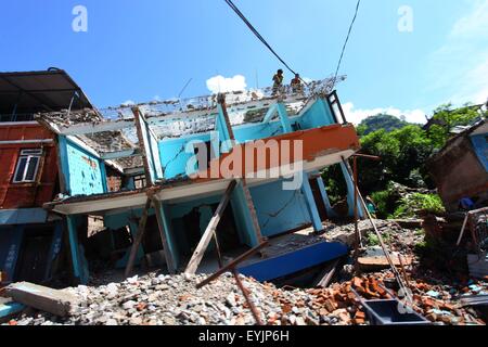 Sindhupalchowk, Nepal. 30. Juli 2015. Arbeiter brechen ein beschädigtes Haus in Sindhupalchowk, Nepal, 30. Juli 2015. Die nepalesische Regierung wurde kritisiert für seine "Unentschlossenheit", den nationalen Wiederaufbau Authority (NRA) nach mehr als drei Monaten April 25 verheerenden Erdbeben in Betrieb zu bringen. © Sunil Sharma/Xinhua/Alamy Live-Nachrichten Stockfoto