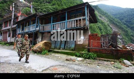 Sindhupalchowk, Nepal. 30. Juli 2015. Armeepersonal gehen vorbei an den beschädigten Haus in Sindhupalchowk, Nepal, 30. Juli 2015. Die nepalesische Regierung wurde kritisiert für seine "Unentschlossenheit", den nationalen Wiederaufbau Authority (NRA) nach mehr als drei Monaten April 25 verheerenden Erdbeben in Betrieb zu bringen. © Sunil Sharma/Xinhua/Alamy Live-Nachrichten Stockfoto
