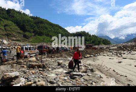 Sindhupalchowk, Nepal. 30. Juli 2015. Eine Frau trägt ihr Hab und gut nach der Blockade der Araniko Autobahn, die durch kontinuierliche Erdrutsche in Sindhupalchowk, Nepal, 30. Juli 2015 betroffen war. Mindestens 26 Menschen wurden getötet und 42 andere fehlen folgende Erdrutsche in Westnepal am Mittwoch Abend, sagten Beamte. © Sunil Sharma/Xinhua/Alamy Live-Nachrichten Stockfoto