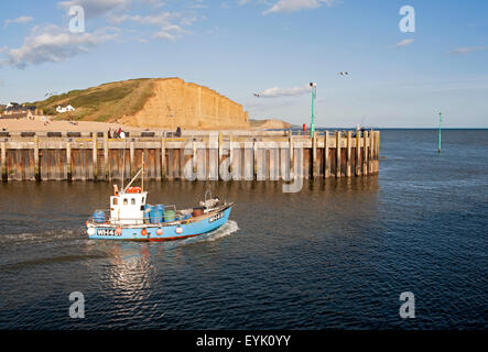 Kleines Fischerboot verlassen den Hafen von West Bay, Bridport, Dorset, England, UK Stockfoto