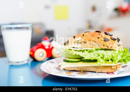 Sandwich, Glas Milch, Spielzeugauto auf Tisch Stockfoto