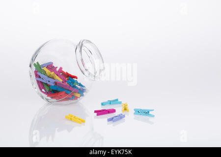 Glas von bunten Miniatur Wäscheklammern auf weißem Hintergrund Stockfoto