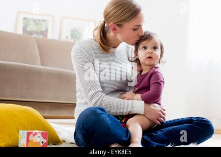 Mutter küssen Baby Boy am Kopf Stockfoto