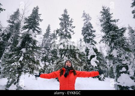 Junge Frau feiert im tief verschneiten Wald, Posio, Lappland, Finnland Stockfoto