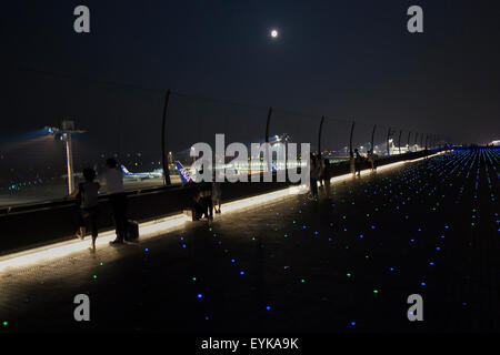 Menschen beobachten Vollmond, wie es über die Skyline von Haneda Airport Terminal 2 am 31. Juli 2015, Tokyo, Japan steigt. Dies ist der zweite Vollmond im Juli und ist bekannt als ein Blue Moon. Es wurde kein zweite Vollmond in einem Monat seit August 2012 und andern bis Januar 2018 wird es nicht geben. © Rodrigo Reyes Marin/AFLO/Alamy Live-Nachrichten Stockfoto