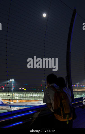 Menschen beobachten Vollmond, wie es über die Skyline von Haneda Airport Terminal 2 am 31. Juli 2015, Tokyo, Japan steigt. Dies ist der zweite Vollmond im Juli und ist bekannt als ein Blue Moon. Es wurde kein zweite Vollmond in einem Monat seit August 2012 und andern bis Januar 2018 wird es nicht geben. © Rodrigo Reyes Marin/AFLO/Alamy Live-Nachrichten Stockfoto