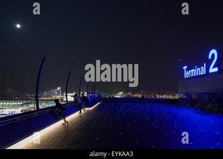 Menschen beobachten Vollmond, wie es über die Skyline von Haneda Airport Terminal 2 am 31. Juli 2015, Tokyo, Japan steigt. Dies ist der zweite Vollmond im Juli und ist bekannt als ein Blue Moon. Es wurde kein zweite Vollmond in einem Monat seit August 2012 und andern bis Januar 2018 wird es nicht geben. © Rodrigo Reyes Marin/AFLO/Alamy Live-Nachrichten Stockfoto