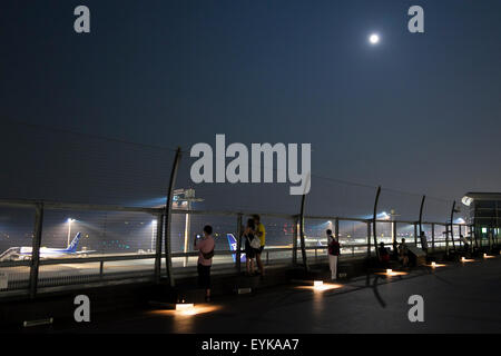 Menschen beobachten Vollmond, wie es über die Skyline von Haneda Airport Terminal 2 am 31. Juli 2015, Tokyo, Japan steigt. Dies ist der zweite Vollmond im Juli und ist bekannt als ein Blue Moon. Es wurde kein zweite Vollmond in einem Monat seit August 2012 und andern bis Januar 2018 wird es nicht geben. © Rodrigo Reyes Marin/AFLO/Alamy Live-Nachrichten Stockfoto