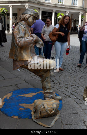 Masse der Touristen betrachten eine lebende Statue balancieren auf einem Bein im Zentrum von Bath, Bath Spa Somerset England UK Stockfoto