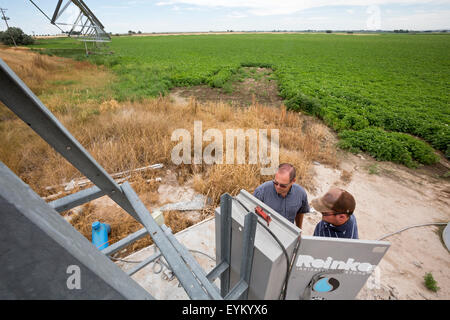 Shelley, Idaho - Idaho Kartoffel Landwirt Bryan Searle (links) und sein Sohn, Ray, passen Sie die Steuerelemente für eine Central Pivot-Bewässerung-sys Stockfoto