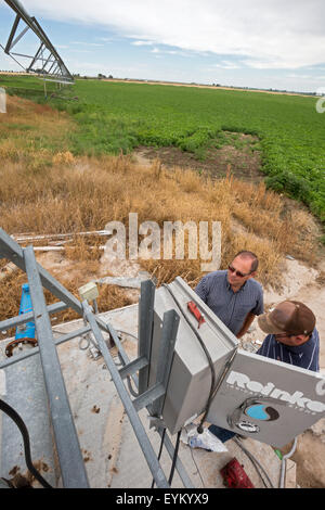 Shelley, Idaho - Idaho Kartoffel Landwirt Bryan Searle (links) und sein Sohn, Ray, passen Sie die Steuerelemente für eine Central Pivot-Bewässerung-sys Stockfoto