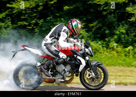 Motorrad, drei-Zylinder-Motor, MV Agusta Brutale 675 Tripistoni, Baujahr 2012, Burnout auf Landstraße, geschwenkt, Rauchen Hinterreifen, Stockfoto