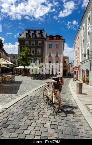 Passauer Altstadt Kopfsteinpflasterstraße am Rindermarkt Bayern Passau Deutschland Frau Fahrradstadt Frau schiebt Fahrrad in leere Straße Stockfoto