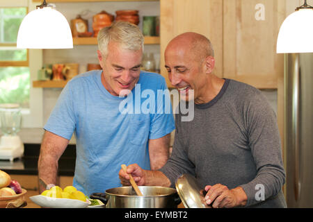 Senior Homosexuell männlichen Partner zu Hause kochen zusammen in der Küche, liebevoll und lächelnd Stockfoto