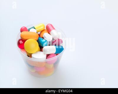 Eine Vielzahl von Pillen in einem Kunststoff-Behälter zu messen. Stockfoto