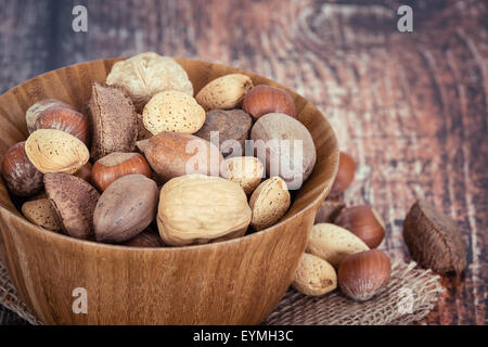 Mischen Sie Muttern mit Mandeln, Walnüsse, Haselnüsse, Pekannüsse und Paranüsse in einer Holzschale rustikalen Hintergrund Stockfoto