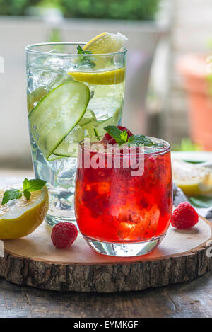 Erfrischende Sommercocktails - Raspberry Crush und Gin Tonic mit Gurke im Hintergrund Stockfoto