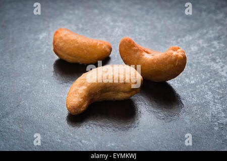 Cashew-Nüssen, Gewürzen auf schwarzem Hintergrund Stockfoto