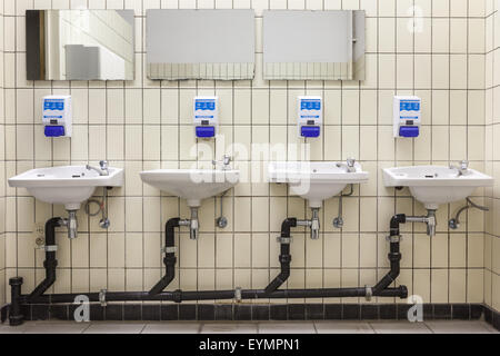 Herren-Toilette in einem öffentlichen Gebäude mit vier sinken Stockfoto