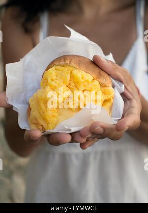 Brioche mit orange Eis, (Brioche Con Gelato). Typische Eiscreme aus Sizilien, Italien. Stockfoto