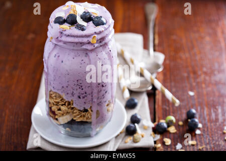 Heidelbeer-Smoothie mit Früchten und Müsli in Glas Stockfoto