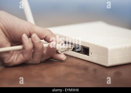 Menschliche Hand, die nur an das WLAN Modem anschließen Stockfoto