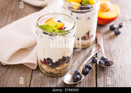 Geschichtete Frühstück Parfait mit Müsli, Pfirsiche oder Beeren Stockfoto