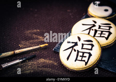 Handbemalte Cookies mit chinesischen Schriftzeichen "Glück", Bambus und Yin Yang. Selektiven Fokus. Stockfoto