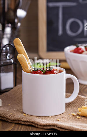 Tomatensuppe in einer Tasse mit gebackenen Tomaten und Mandeln Stockfoto