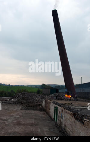 1 aus einer Reihe von 13 Aufnahmen von einem Ziegelstein gebaut Schornstein einem Zusammenbruch nach wird durch die alte Lagerfeuer Methode gefällt. Stockfoto