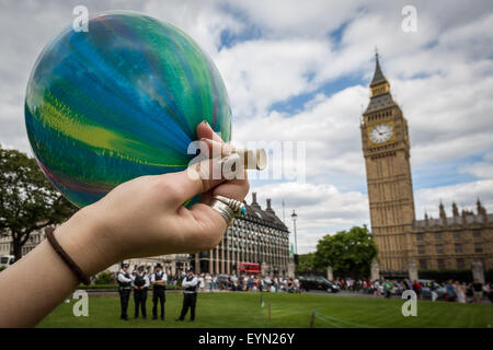 London, Großbritannien. 1. August 2015. Mitkämpfer inhalieren mit Lachgas Luftballons aufgeblasen, allgemein bekannt als "lachgas" hoch während einer Protestaktion von Westminster Parliament Square gegen einen Gesetzentwurf, der darauf abzielt, zu machen Verkauf illegaler psychoaktiver Substanzen zu erhalten. Credit: Guy Corbishley/Alamy leben Nachrichten Stockfoto