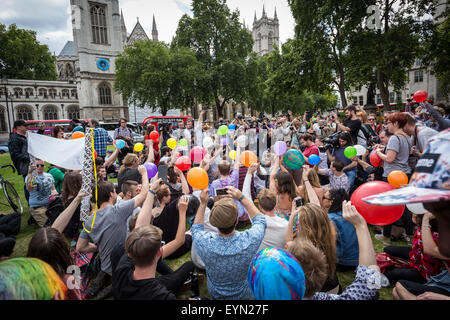 London, Großbritannien. 1. August 2015. Mitkämpfer inhalieren mit Lachgas Luftballons aufgeblasen, allgemein bekannt als "lachgas" hoch während einer Protestaktion von Westminster Parliament Square gegen einen Gesetzentwurf, der darauf abzielt, zu machen Verkauf illegaler psychoaktiver Substanzen zu erhalten. Credit: Guy Corbishley/Alamy leben Nachrichten Stockfoto