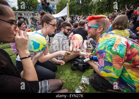 London, Großbritannien. 1. August 2015. Mitkämpfer inhalieren mit Lachgas Luftballons aufgeblasen, allgemein bekannt als "lachgas" hoch während einer Protestaktion von Westminster Parliament Square gegen einen Gesetzentwurf, der darauf abzielt, zu machen Verkauf illegaler psychoaktiver Substanzen zu erhalten. Credit: Guy Corbishley/Alamy leben Nachrichten Stockfoto